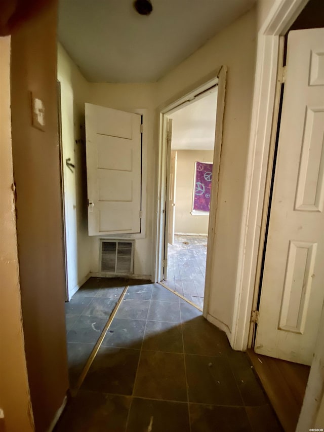 corridor with visible vents and dark tile patterned floors