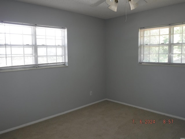 spare room with carpet, ceiling fan, and baseboards