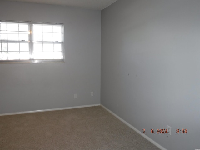 empty room featuring carpet flooring and baseboards