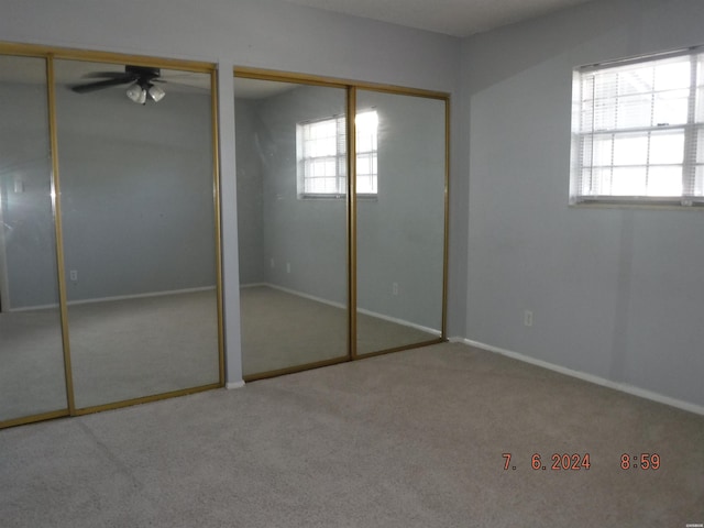 unfurnished bedroom with carpet floors, baseboards, and two closets