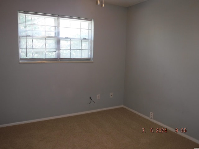 carpeted empty room featuring baseboards