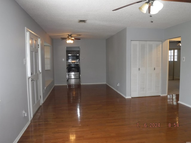 unfurnished room featuring baseboards, a textured ceiling, visible vents, and dark wood-type flooring