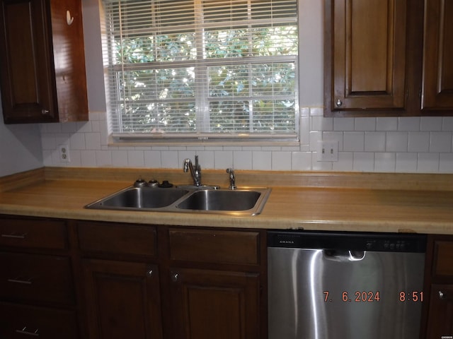 kitchen featuring a wealth of natural light, tasteful backsplash, light countertops, stainless steel dishwasher, and a sink