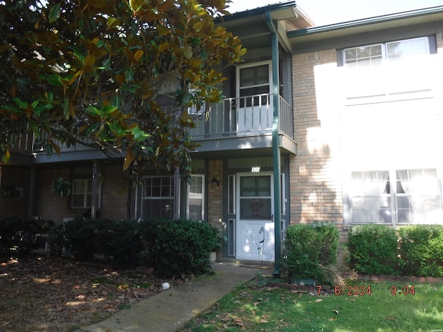 exterior space featuring brick siding and a balcony