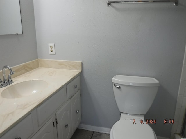 bathroom with toilet, tile patterned floors, vanity, and baseboards