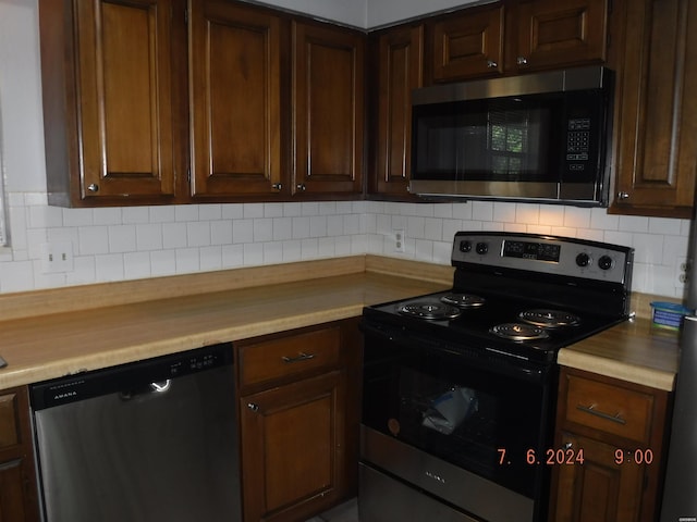 kitchen featuring stainless steel appliances, tasteful backsplash, wooden counters, and dark brown cabinetry