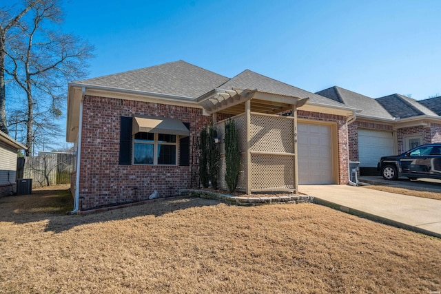 view of front of house featuring a garage, concrete driveway, brick siding, and roof with shingles