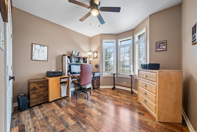 home office with dark wood-style flooring, ceiling fan, and baseboards