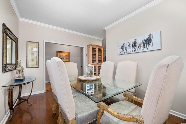 dining room featuring crown molding, baseboards, and wood-type flooring