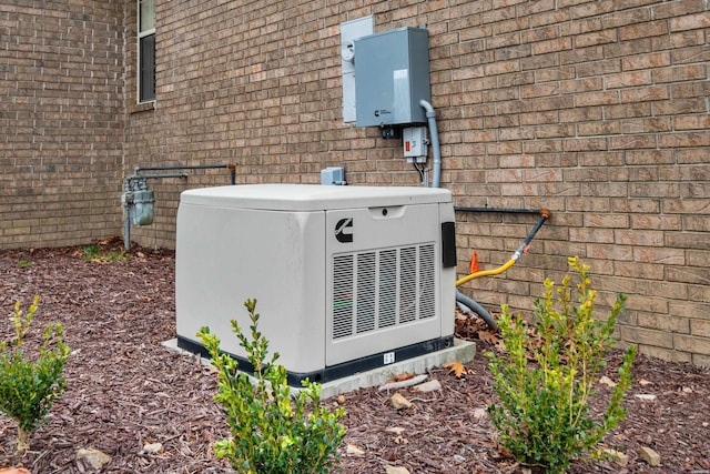 details with brick siding, gas meter, and a power unit