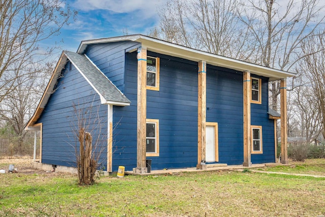 view of front of property featuring a shingled roof and a front lawn