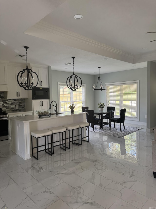 202 Quail Ridge Dr, Hot Springs, AR 71901 - kitchen with a chandelier, black microwave, stainless steel electric stove, crown molding, and a kitchen breakfast bar