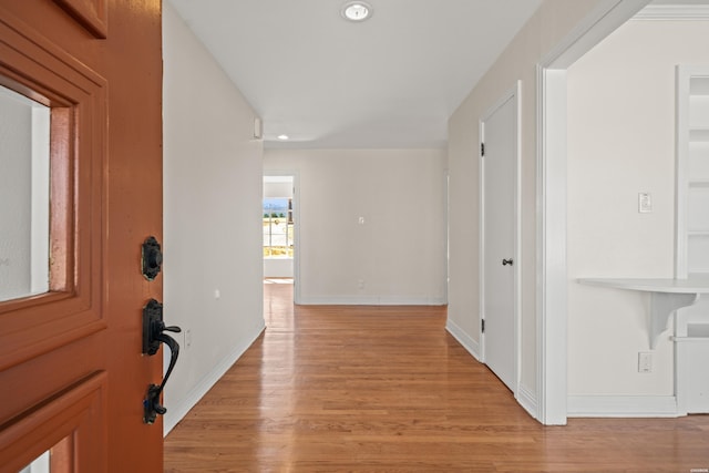 hallway featuring light wood-type flooring, baseboards, and recessed lighting