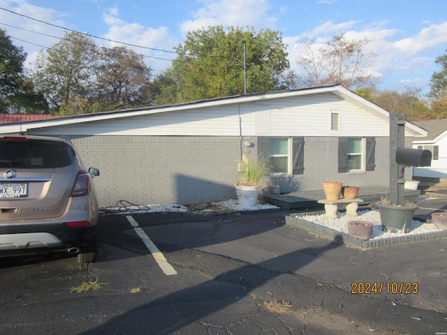 view of front of property with uncovered parking and brick siding