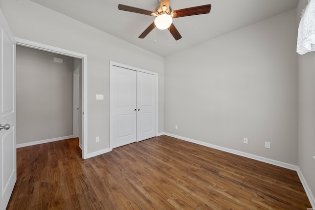 unfurnished bedroom featuring a ceiling fan, a closet, baseboards, and wood finished floors