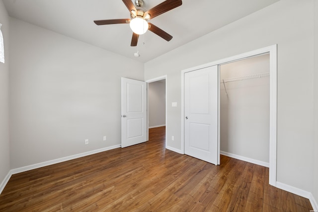 unfurnished bedroom featuring a closet, dark wood-style flooring, baseboards, and a ceiling fan