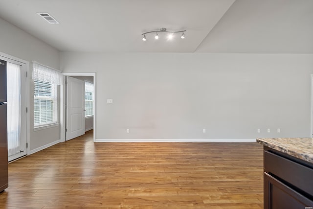 interior space with light wood finished floors, visible vents, and baseboards