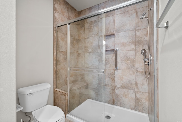 bathroom with a shower stall and toilet