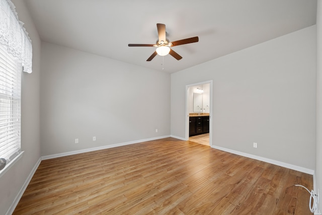 empty room with light wood-style floors, ceiling fan, and baseboards