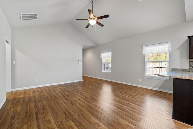 unfurnished living room featuring a healthy amount of sunlight, a ceiling fan, visible vents, and wood finished floors