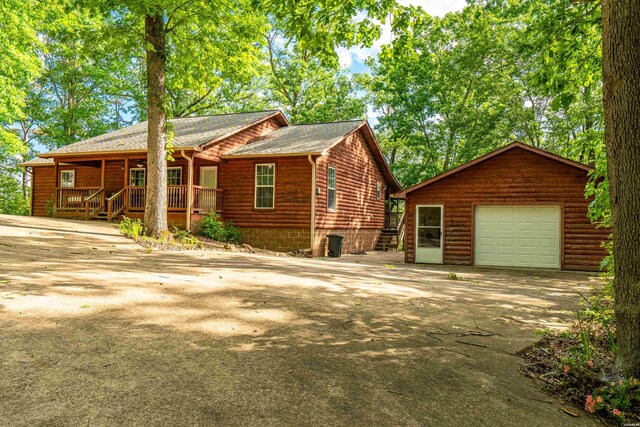 67 Delton Mccauley Rd, Kirby, AR 71950 - rustic home with concrete driveway, an outbuilding, a garage, and covered porch