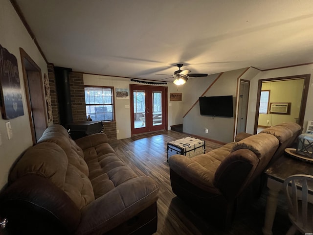 living area with ceiling fan, french doors, dark wood-style floors, a wall mounted air conditioner, and a wood stove