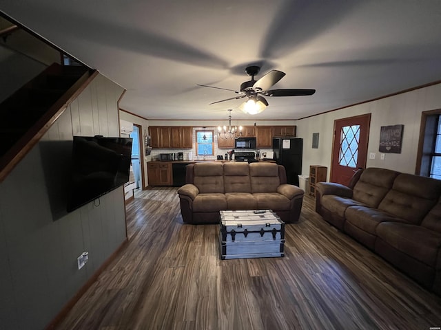 living room featuring dark wood-style floors, ornamental molding, and ceiling fan with notable chandelier