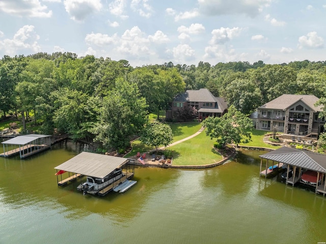 dock area featuring a water view, a lawn, boat lift, and a wooded view