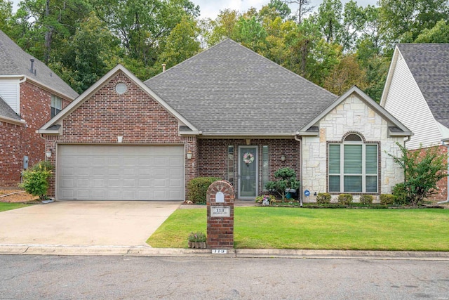 view of front facade featuring a garage, driveway, stone siding, roof with shingles, and a front yard