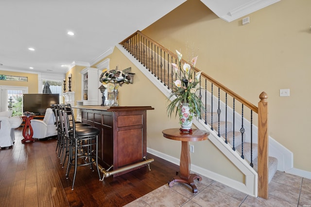 bar with stairs, ornamental molding, and baseboards