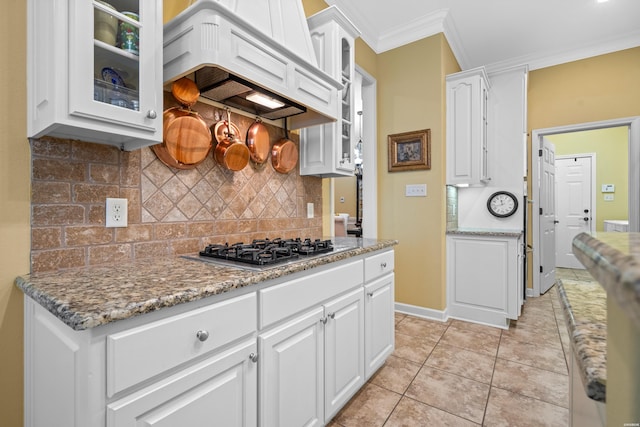 kitchen with stainless steel gas cooktop, premium range hood, white cabinetry, ornamental molding, and glass insert cabinets