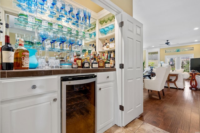 bar with a bar, wine cooler, wood finished floors, and recessed lighting