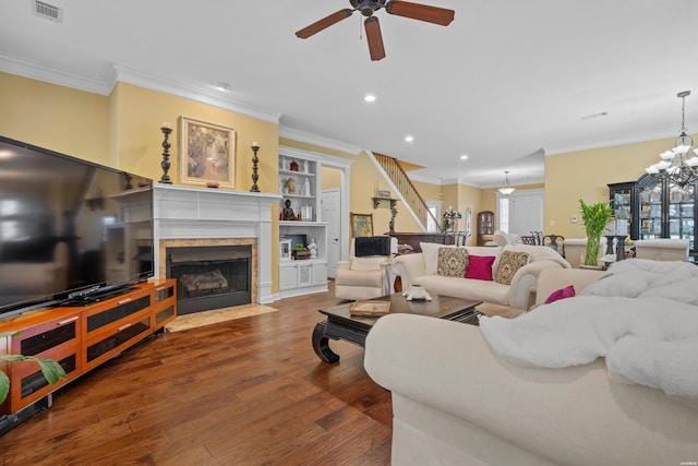 living room featuring a fireplace, recessed lighting, visible vents, ornamental molding, and wood finished floors