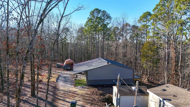 view of side of home with an outbuilding and a wooded view