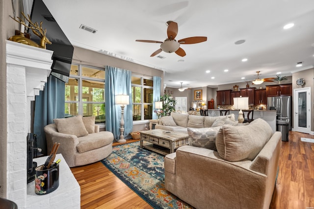 living area featuring a ceiling fan, recessed lighting, visible vents, and wood finished floors