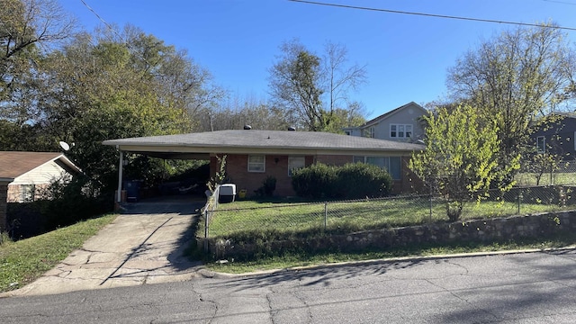 view of front facade with driveway, a carport, and a fenced front yard