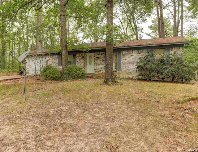 ranch-style home featuring a front yard and brick siding