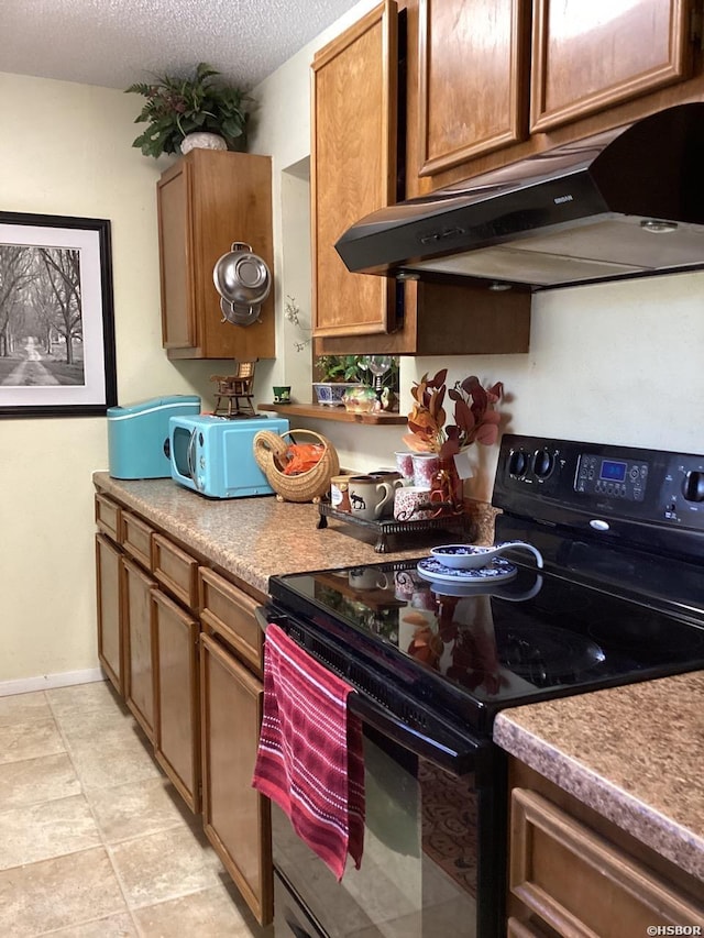 kitchen featuring black / electric stove, brown cabinetry, a textured ceiling, under cabinet range hood, and baseboards