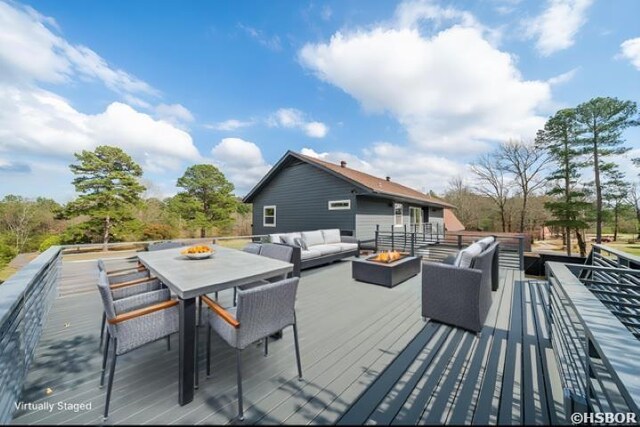 wooden terrace featuring an outdoor living space with a fire pit