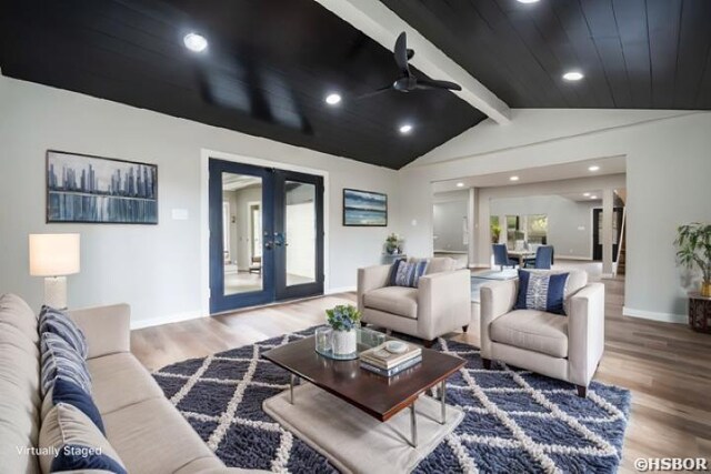 living room with baseboards, a ceiling fan, lofted ceiling with beams, wood finished floors, and french doors