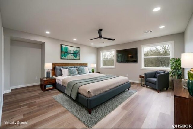 bedroom with baseboards, wood finished floors, visible vents, and recessed lighting