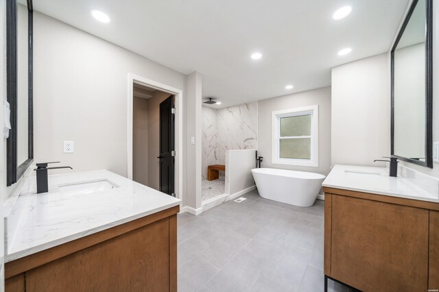 bathroom featuring a marble finish shower, two vanities, a sink, and recessed lighting