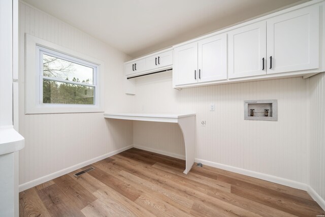 clothes washing area with baseboards, hookup for a washing machine, cabinet space, and light wood-style floors