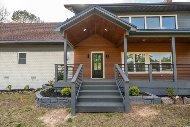 entrance to property featuring a shingled roof