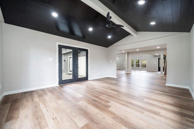 unfurnished living room with lofted ceiling with beams, light wood-type flooring, baseboards, and french doors