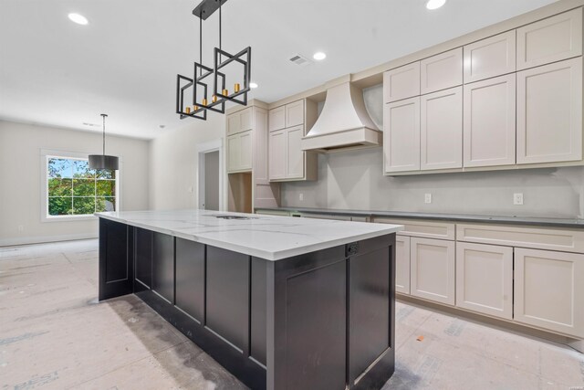 kitchen with light stone counters, recessed lighting, pendant lighting, and premium range hood