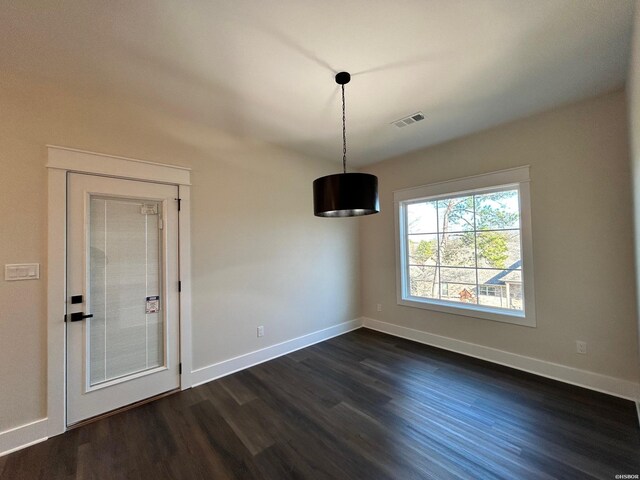 unfurnished dining area with dark wood-style floors, visible vents, and baseboards