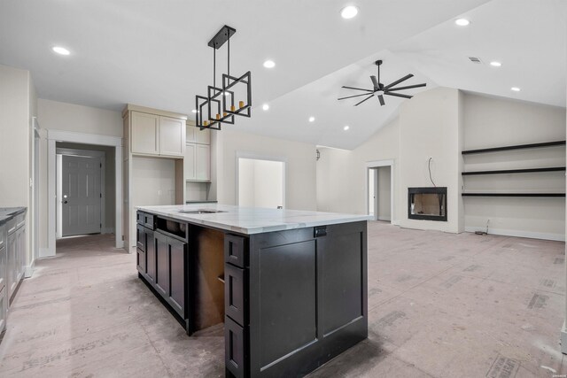 kitchen featuring light stone counters, dark cabinets, a kitchen island with sink, vaulted ceiling, and pendant lighting