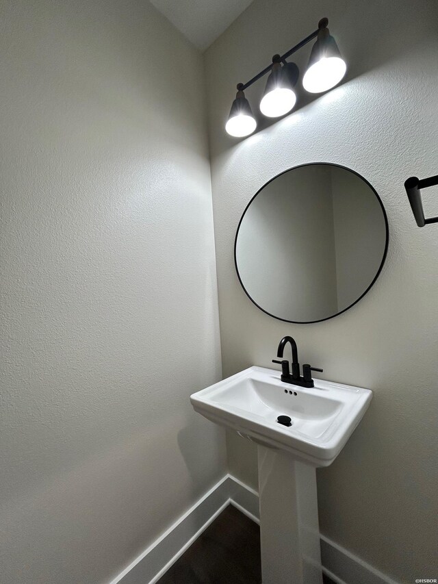 bathroom with a sink and baseboards