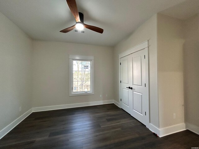 unfurnished bedroom featuring dark wood-style floors, ceiling fan, visible vents, and baseboards